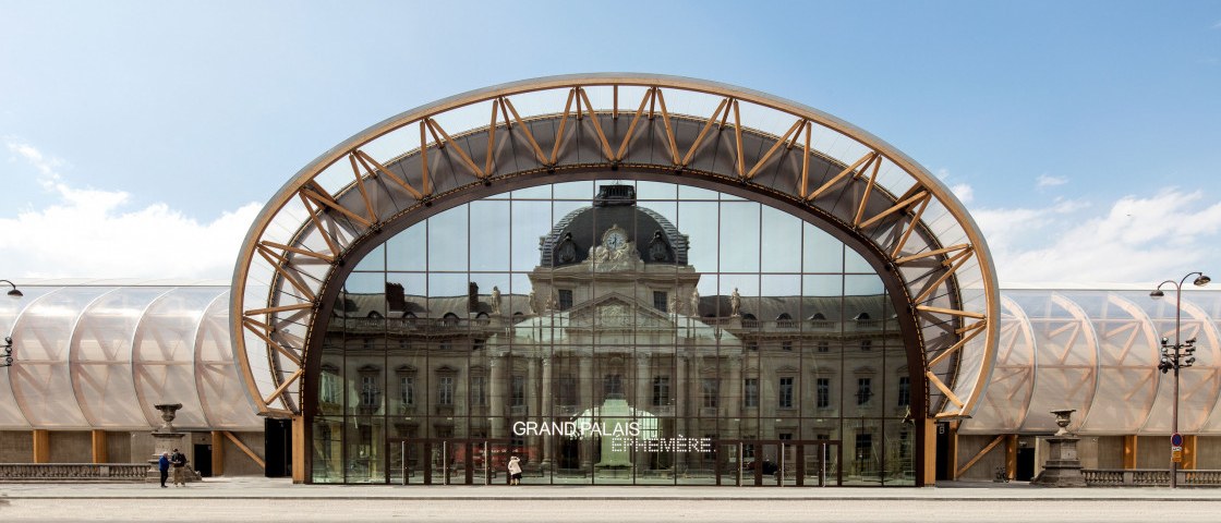 The Grand Palais Éphémère in Paris, its timber arch framing the facade behind the glass